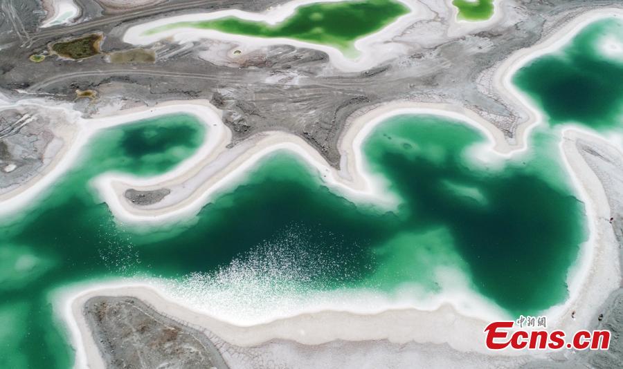 Da Qaidam salt lake in Haixi Mongol and Tibetan Autonomous Prefecture, Qinghai Province, July 25, 2018. The salt lake covering six square kilometers was formed by many years of mining, leaving a high concentration of salt called brine. It was named Emerald Lake because of its different and beautiful colors against the blue sky and snow-covered mountains. (Photo: China News Service/Liu Zhongjun)