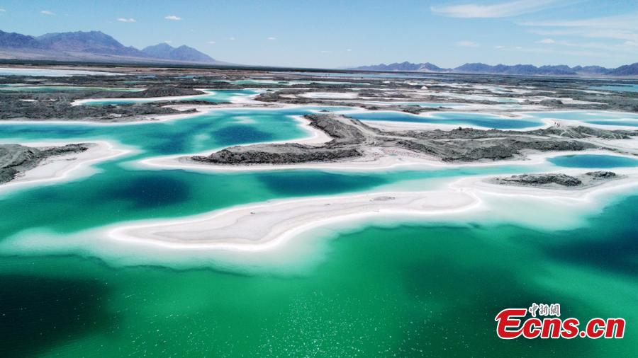 Da Qaidam salt lake in Haixi Mongol and Tibetan Autonomous Prefecture, Qinghai Province, July 25, 2018. The salt lake covering six square kilometers was formed by many years of mining, leaving a high concentration of salt called brine. It was named Emerald Lake because of its different and beautiful colors against the blue sky and snow-covered mountains. (Photo: China News Service/Liu Zhongjun)