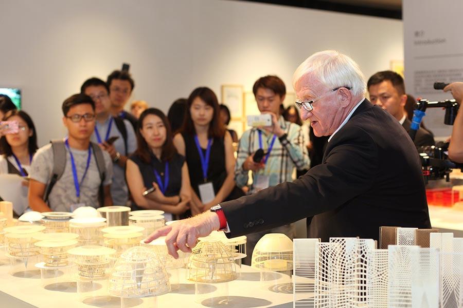 Spencer de Grey, the senior executive partner and head of design at Foster Partners, gives a tour of the exhibition at Tsinghua University Art Museum (Photo provided to China Daily)
