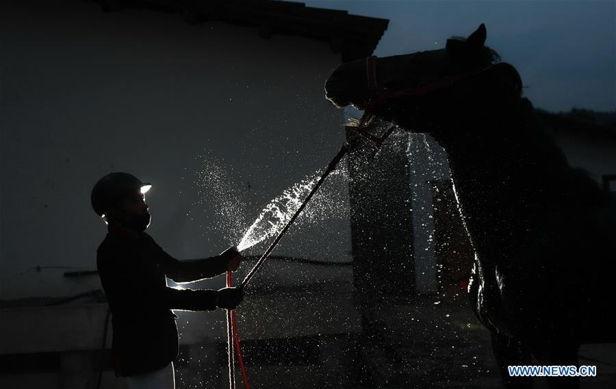 A student of Sunshine Riding School washes a horse after a training session in Yihuang County of Fuzhou, east China\'s Jiangxi Province, March 14, 2018. Equestrianism had never been heard of in Yihuang, an agricultural county in east China\'s Jiangxi Province, until Sunshine Riding School began recruiting rural teenagers in 2015. So far, most of the 90 students are working or aspiring to work in horse riding clubs in China\'s largest cities such as Beijing, Shanghai and Hangzhou. (Xinhua/Zhou Mi)