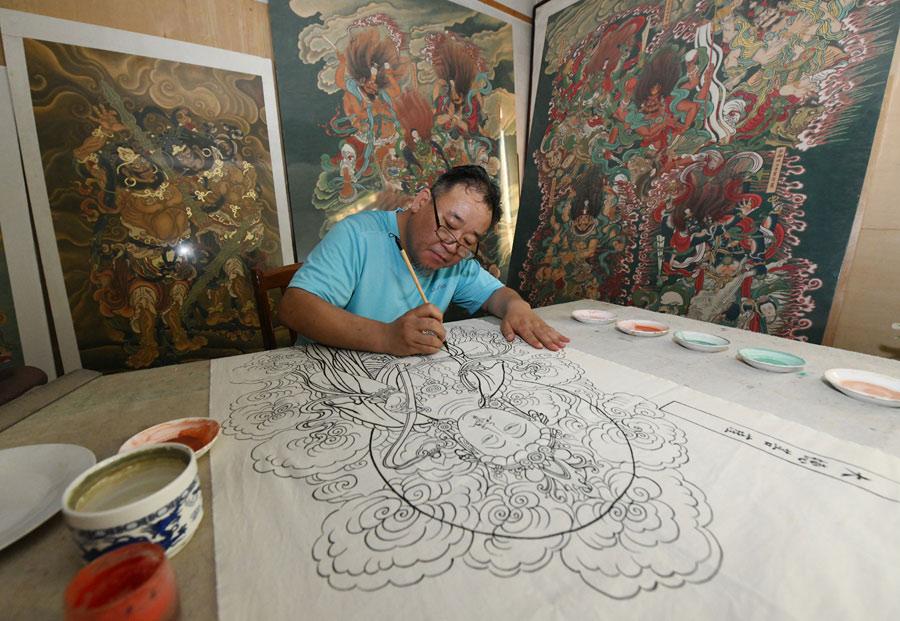 Yao Shulong creates replicas of traditional Chinese New Year paintings of Pilu Temple in his studio on July 24, 2018. （Photo/Xinhua）
