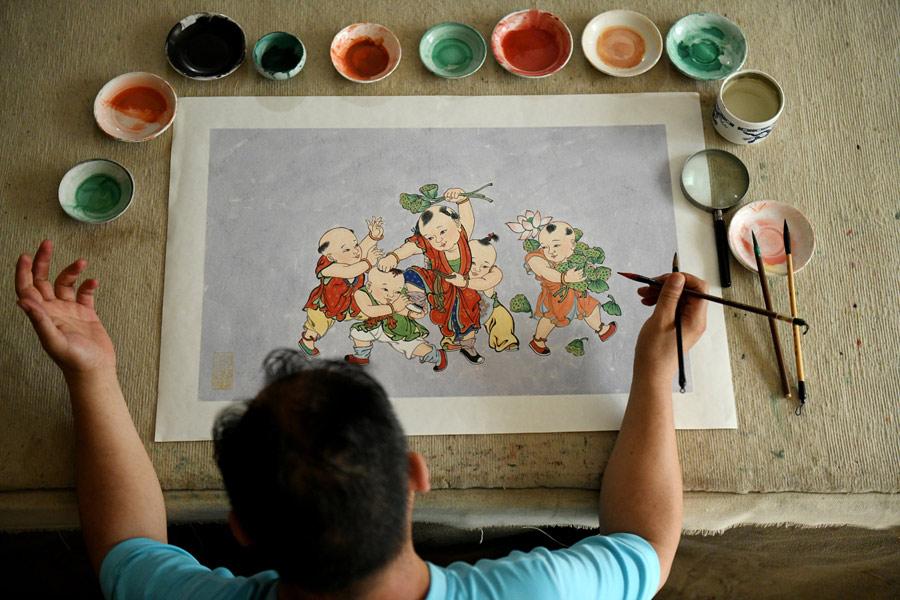 Yao Shulong draws a traditional Chinese New Year painting using mural techniques in his studio on July 24, 2018. (Photo/Xinhua)

Folk painter Yao Shulong was taken by his father to Pilu Temple in North China\'s Hebei Province at age 6, and ever since then he has built a special connection with murals in the temple.

In 2006, he began to make replicas of the murals on paper. After 10 years of practicing line drawing, coloring and powdering, he has managed to make life-size replicas of the murals spanning more than 200 square meters on paper.

Through exhibitions and lecture tours in colleges over the past two years, Yao has promoted traditional murals to wider public audiences.