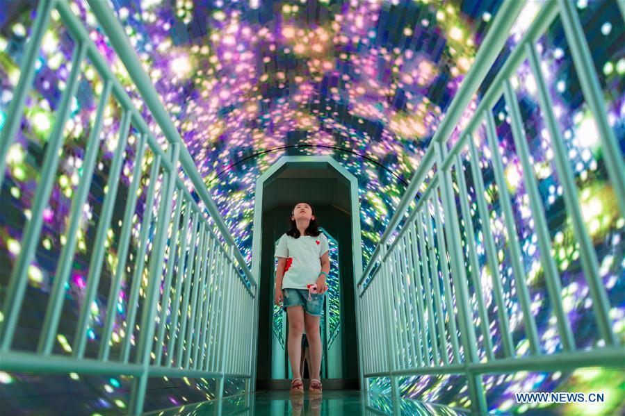 A girl walks through a corridor in Inner Mongolia Science and Technology Museum in Hohhot, north China\'s Inner Mongolia Autonomous Region, July 27, 2018. Children take part in various classes and activities to enrich their summer vacation life. (Xinhua/Ding Genhou)