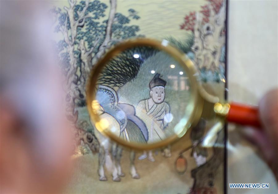 A visitor views a Suzhou embroidery exhibit during an exhibition in Suzhou, east China\'s Jiangsu Province, July 29, 2018. The exhibition displayed Wang Qin\'s collections and creations of Suzhou embroidery version of classic Chinese painting works. (Xinhu