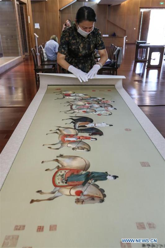 Wang Qin arranges Suzhou embroidery exhibits after an exhibition in Suzhou, east China\'s Jiangsu Province, July 29, 2018. An exhibition displaying Wang Qin\'s collections and creations of Suzhou embroidery version of classic Chinese painting works concluded in Suzhou on Sunday. (Xinhua/Yang Lei)