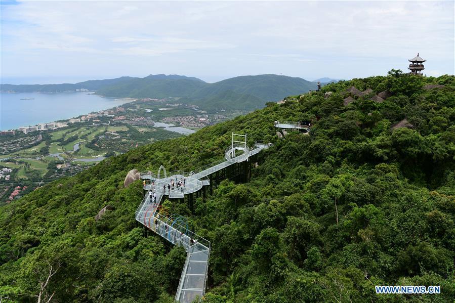 People visit a glass plank road built at the Yalong Bay forest park in Sanya, south China\'s Hainan Province, July 29, 2018. The 400-meter-long plank road will open for tourists in August. (Xinhua/Sha Xiaofeng)
