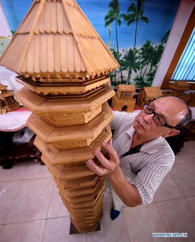 Zhang Xiaocheng checks a model of ancient building made of discarded wooden sticks in Chengguan Town of Wu\'an City, north China\'s Hebei Province, July 31, 2018. 70-year-old Zhang has made over 60 handicrafts using discarded wooden sticks. (Xinhua/Wang Xiao)