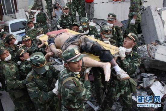 PLA soldiers carry a wounded man after an earthquake in Wenchuan county, Sichuan Province, May 15, 2008. (Photo/Xinhua)