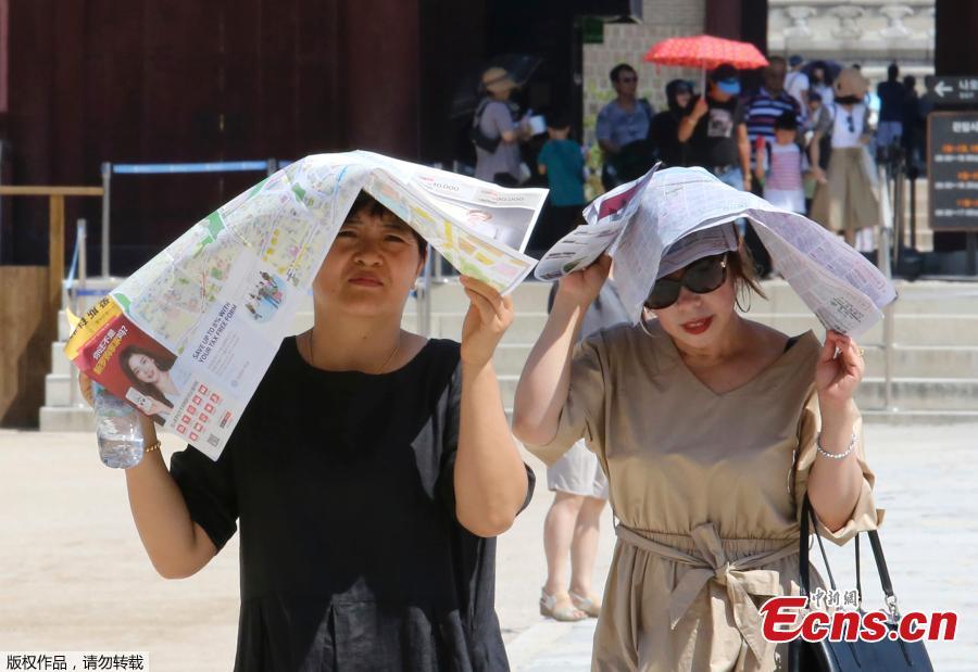 Women use papers to avoid sunshine at the Gyeongbok Palace, the main royal palace during the Joseon Dynasty, in Seoul, South Korea, Aug. 1, 2018. South Korean Meteorological Administration issued a heat wave warning for Seoul and other cities. Seoul logged its highest-ever temperature of 38.8 C on Wednesday since 1907. (Photo/Agencies)