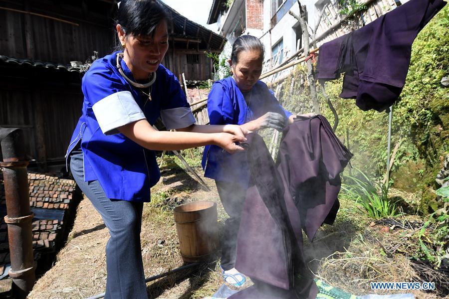 Women of the Dong ethnic group dry Dong cloth at Linxi Village of Sanjiang Dong Autonomous County under Liuzhou City, south China\'s Guangxi Zhuang Autonomous Region, Aug. 4, 2018. Summer is the best season for the people of the Dong ethnic group to make their traditional Dong cloth in ancient ways with natural materials. It is popular among the Dong people for its shining look in the sun and cozy quality for wearing. (Xinhua/Li Hanchi)