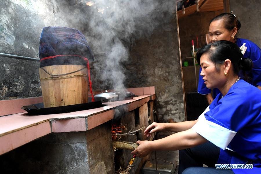 Women of the Dong ethnic group steam dyed Dong cloth at Linxi Village of Sanjiang Dong Autonomous County under Liuzhou City, south China\'s Guangxi Zhuang Autonomous Region, Aug. 4, 2018. Summer is the best season for the people of the Dong ethnic group to make their traditional Dong cloth in ancient ways with natural materials. It is popular among the Dong people for its shining look in the sun and cozy quality for wearing. (Xinhua/Li Hanchi)