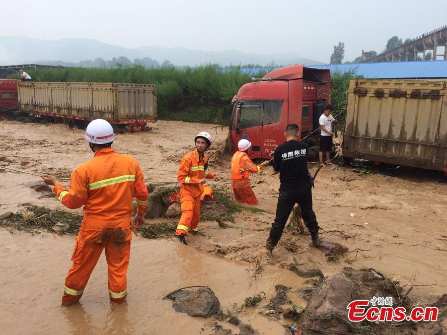 Rescuers help a driver escape from a truck trapped by mountain torrents in Fudian Town, Yanshi City, Central China’s Henan Province, Aug. 5, 2018. Fifteen drivers were saved after a flash flood caused by a two-hour rainstorm trapped 50 trucks. (Photo/VCG)