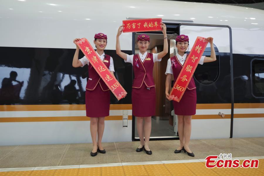 Attendants celebrate the start of Fuxing train running along the Beijing-Tianjin intercity high-speed railway at 350 kilometers per hour, up from 300 km/h, on Aug. 8, 2018. The Beijing-Tianjin intercity high-speed railway, one of China\'s calling cards, opened in August 2008. In 10 years, it has carried 250 million passengers. The new bullet train cuts the travel time between two cities from 35 minutes to 30 minutes. (Photo: China News Service/Jia Tianyong)