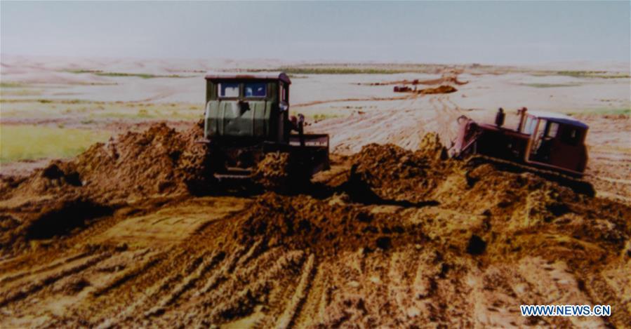 File photo shows people building a road at the Kubuqi Desert in 1990s, in Hangjin Banner, north China\'s Inner Mongolia Autonomous Region. Kubuqi, the seventh largest desert in China, is a good example of China\'s success in alleviating desertification. About 6,460 square kilometers of the Kubuqi desert has been reclaimed in the last 30 years. (Xinhua)