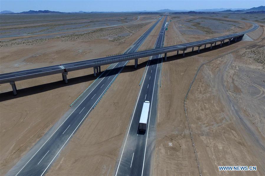 Aerial photo taken on July 15, 2017 shows a truck running on the Beijing-Urumqi Expressway in Hami, northwest China\'s Xinjiang Uygur Autonomous Region. As an important link of the Silk Road Economic Belt, Xinjiang is speeding up the development of transportation and logistics to connect east and west. By the end of 2017, the total length of roads in Xinjiang reached 186,000 km, with 4,578 km of expressways. (Xinhua/Cai Zengle)