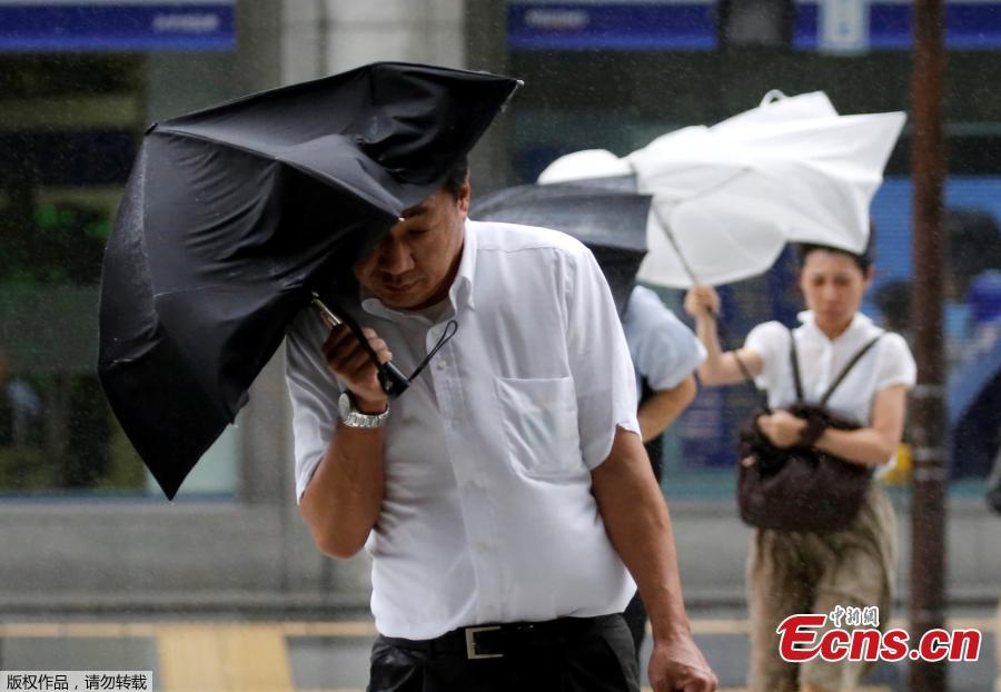 Passersby using umbrellas struggle against a heavy rain and wind as Typhoon Shanshan approaches Japan\'s mainland in Tokyo, Japan, Aug. 8, 2018. (Photo/Agencies)