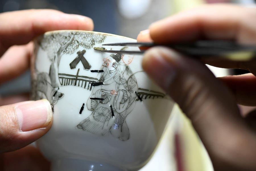Li Junhang, a Hebei-based inheritor of the old craft of juci, or porcelain restoration, embeds a nail into a broken porcelain ware to make it complete. Over the past two decades, Li has infused Chinese calligraphy and painting into the ancient repair skill, adding artistic flairs to broken ceramic wares. (Photo/Xinhua)