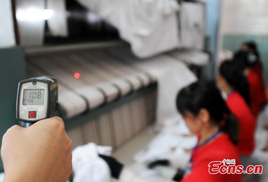 Workers clean bedding for sleeper carriages on trains in Jiujiang City, East China’s Jiangxi Province, Aug. 8, 2018. During the summer travel peak, laundry service workers have to clean up to 20,000 sets of linen a day, double their normal workload, despite the high temperatures at 50 degrees centigrade. (Photo: China News Service/Hu Guolin)