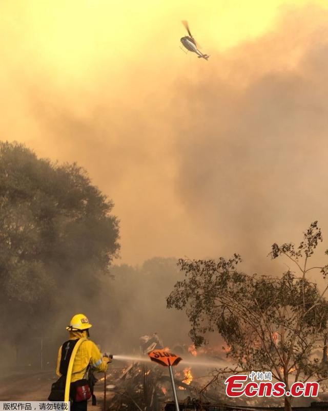 Firefighters battle wildfires as a helicopter hovers above an area near Mendocino National Forest, California, the U.S. August 4,  2018 in this picture obtained from social media. (Photo/Agencies)
