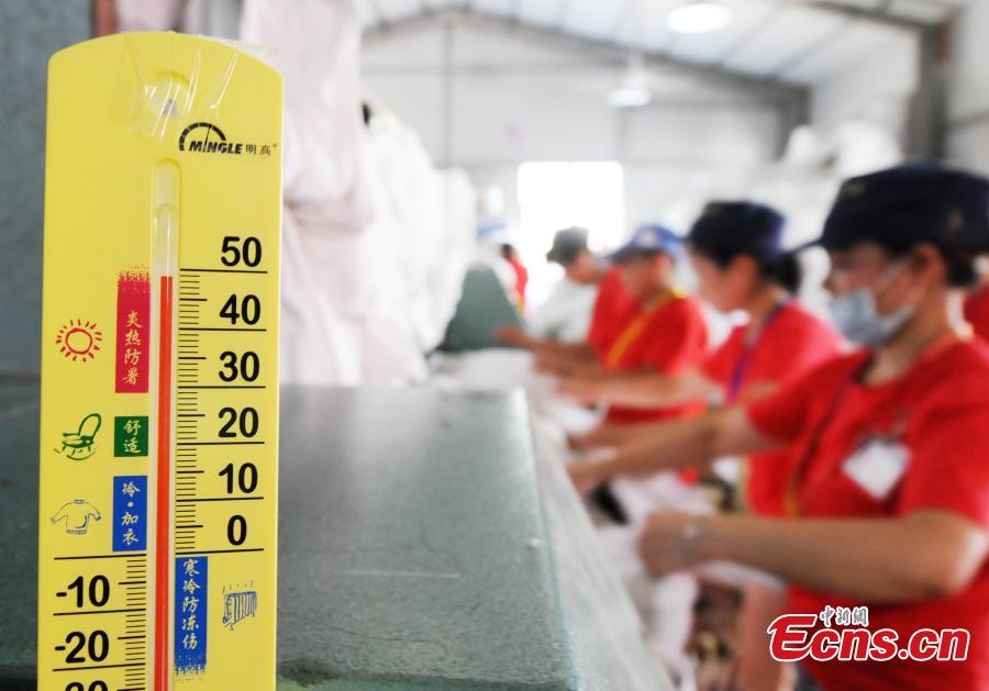 Workers clean bedding for sleeper carriages on trains in Jiujiang City, East China’s Jiangxi Province, Aug. 8, 2018. During the summer travel peak, laundry service workers have to clean up to 20,000 sets of linen a day, double their normal workload, despite the high temperatures at 50 degrees centigrade. (Photo: China News Service/Hu Guolin)