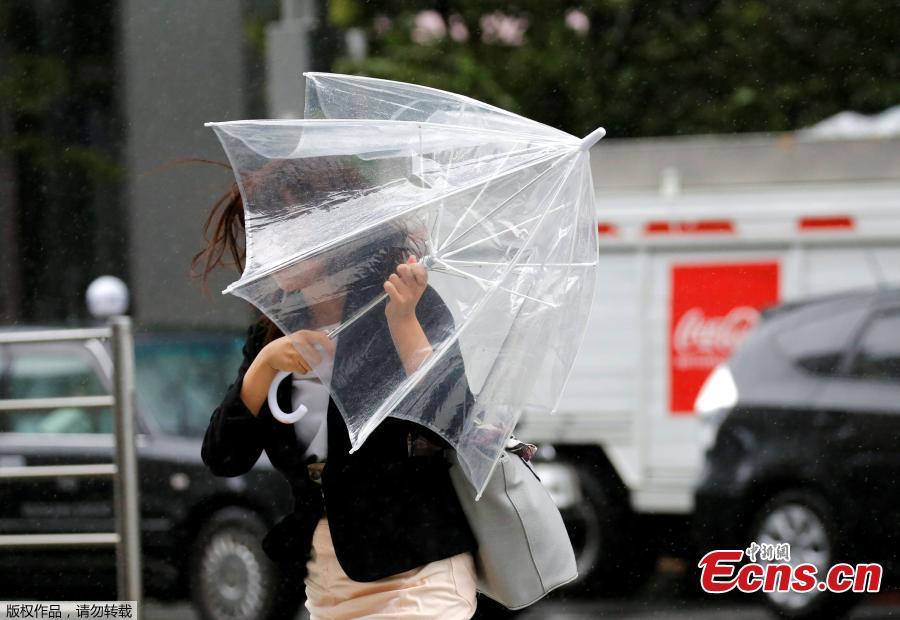 A woman using an umbrella struggles against a heavy rain and wind as Typhoon Shanshan approaches Japan\'s mainland in Tokyo, Japan, Aug. 8, 2018. (Photo/Agencies)