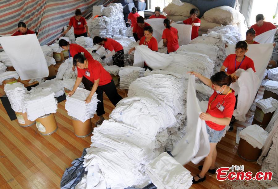 Workers clean bedding for sleeper carriages on trains in Jiujiang City, East China’s Jiangxi Province, Aug. 8, 2018. During the summer travel peak, laundry service workers have to clean up to 20,000 sets of linen a day, double their normal workload, despite the high temperatures at 50 degrees centigrade. (Photo: China News Service/Hu Guolin)