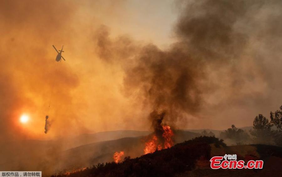 Firefighters battle wildfires as a helicopter hovers above an area near Mendocino National Forest, California, the U.S., Aug. 4, 2018 in this image obtained from social media. (Photo/Agencies)