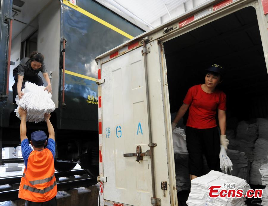 Railway workers transport clean bed linen destined for sleeper carriages on trains in Jiujiang City, East China’s Jiangxi Province, Aug. 8, 2018. During the summer travel peak, laundry service workers have to clean up to 20,000 sets of linen a day, double their normal workload, despite the high temperatures at 50 degrees centigrade. (Photo: China News Service/Hu Guolin)