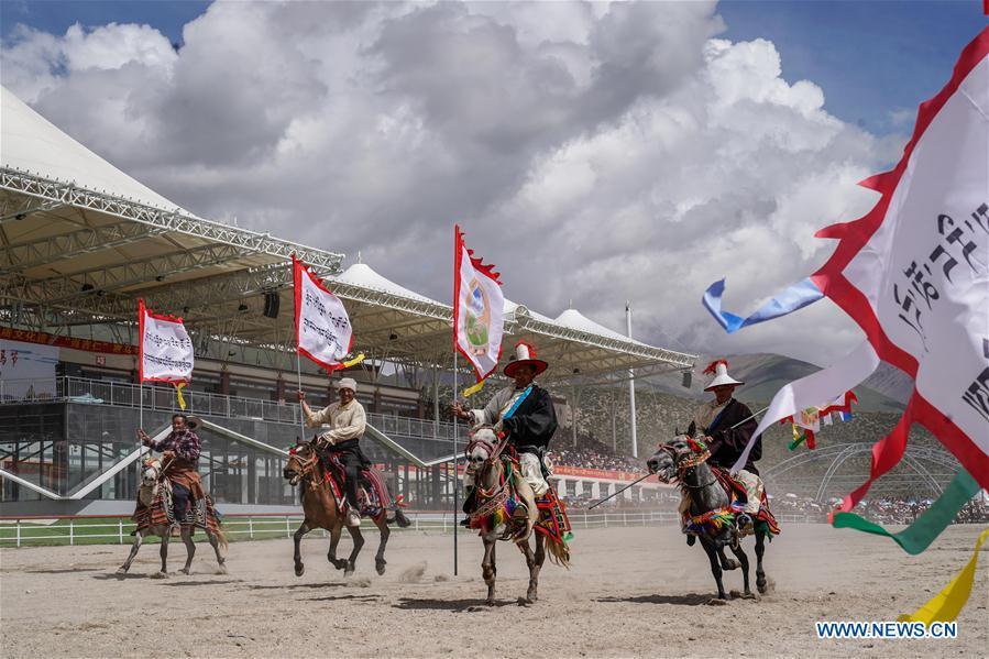 Riders enter the race course during the opening ceremony of a horse racing festival in Damxung County, southwest China\'s Tibet Autonomous Region, Aug. 8, 2018. Dangjiren horse racing is originated from military parade of Mongolian cavalry since 17th century. (Xinhua/Cen Yunpeng)