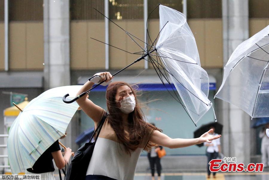 A woman using an umbrella struggles against a heavy rain and wind as Typhoon Shanshan approaches Japan\'s mainland in Tokyo, Japan, Aug. 8, 2018. (Photo/Agencies)