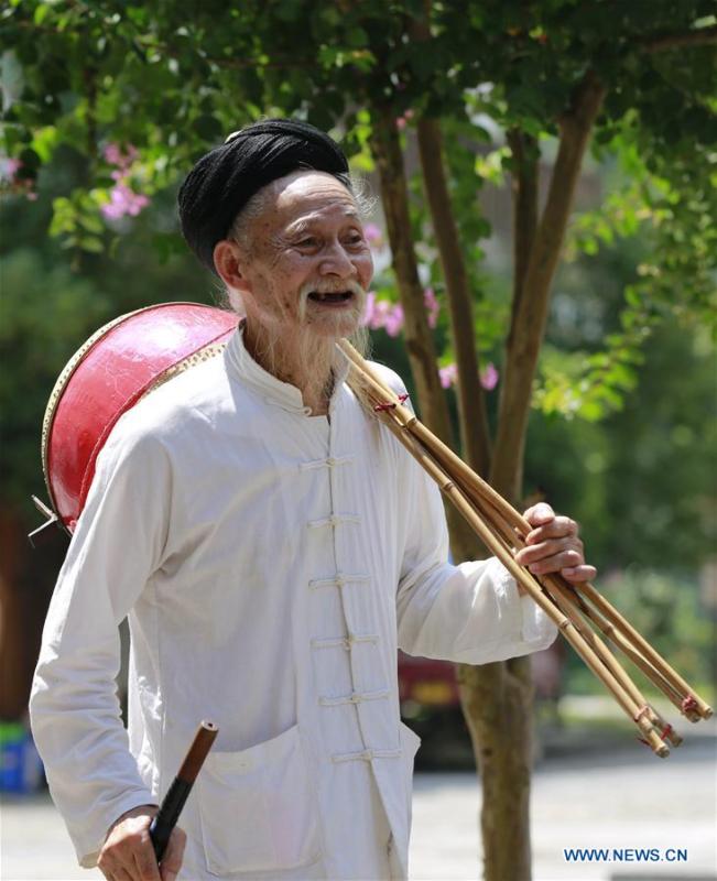 Jin De\'an prepares to perform Daliuzi at Xibu Street, a scenic spot in the Wulingyuan District of Zhangjiajie City, central China\'s Hunan Province, Aug. 7, 2018. Daliuzi is a kind of local musical instrument performance with a long history. Jin De\'an is the creator of \