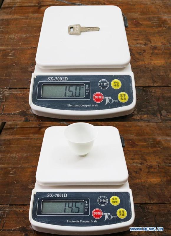Combination photo taken on Aug. 9, 2018 shows the weight of a key (15 grams) (upper) and the weight of a tea cup (14.5 grams) made by the \