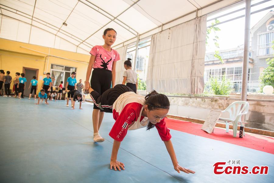 Twin sisters Wei Liufei (L) and Wei Meifei, 12, train at a gym in Nanning, the capital of South China’s Guangxi Zhuang Autonomous Region, Aug. 9, 2018. Most of the children training with the acrobatics troupe led by Li Dewei are from the poverty-stricken Mashan County and they dream of one day improving the financial position of their families through their performances. (Photo: China News Service/Chen Guanyan)