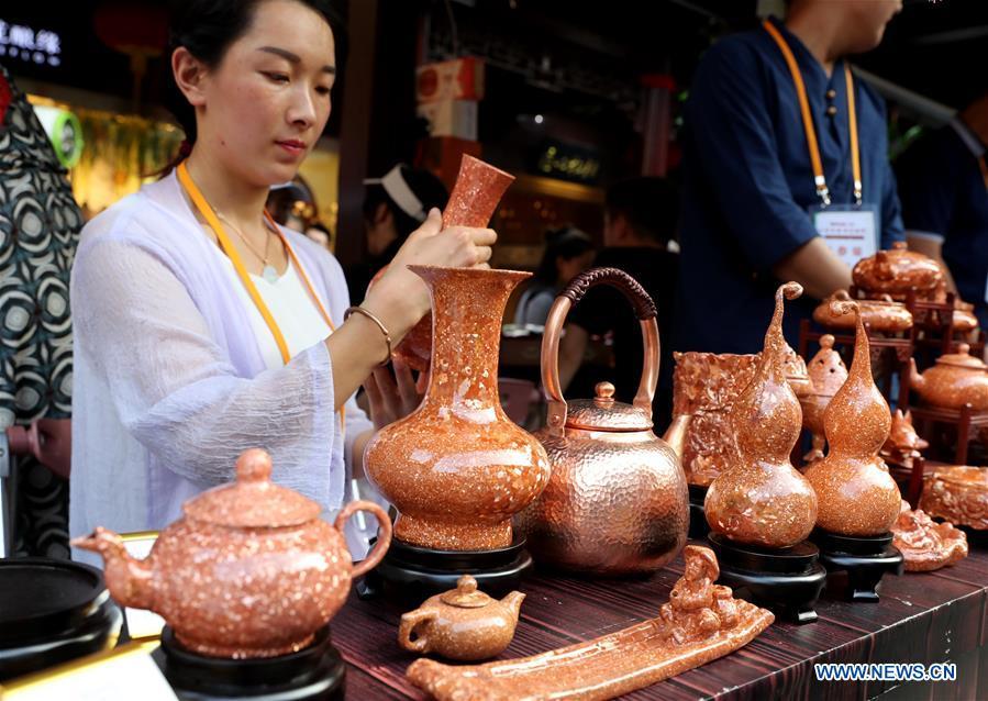 Local artwares are seen at the Yunnan folk art exhibition at Yuyuan Garden in east China\'s Shanghai, Aug. 10, 2018. The exhibition kicked off here on Friday and shows folk dances, local artwares and scenery from Qujing City of Yunnan Province. (Xinhua/Liu Ying)
