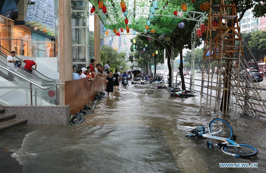 Bikes are swept down by the flood in Haikou, south China\'s Hainan Province, Aug. 10, 2018. Hainan was hit by heavy rainfalls under the influence of a tropical depression on Friday, which triggered a red alert for rainstorms in seven cities and counties, including Haikou. (Xinhua/Wang Junfeng)