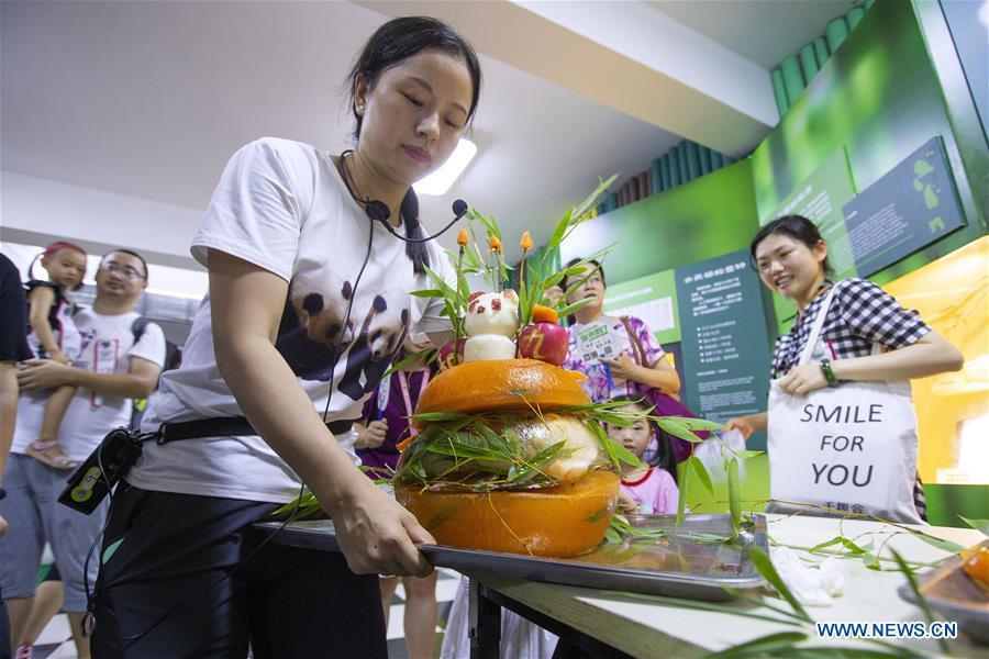 A staff worker shows a birthday cake prepared for the giant panda twins Hehe and Jiujiu at the Nanjing Hongshan Forest Zoo in Nanjing, capital of east China\'s Jiangsu Province, Aug. 10, 2018. Staff workers at the zoo celebrated the 3rd birthday anniversary for the female giant panda twins \