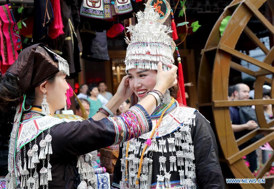 Dancers prepare for a performance at the Yunnan folk art exhibition at Yuyuan Garden in east China\'s Shanghai, Aug. 10, 2018. The exhibition kicked off here on Friday and shows folk dances, local artwares and scenery from Qujing City of Yunnan Province. (Xinhua/Liu Ying)