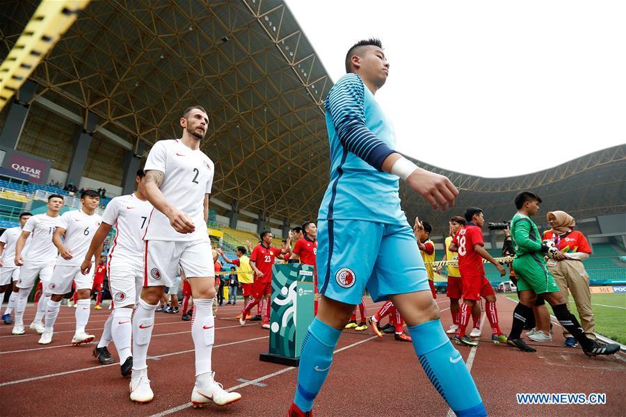 Players of Hong Kong of China and Laos enter the field before the Men\'s Football Group A match between Hong Kong of China and Laos at the 18th Asian Games at Patriot Stadium in Bekasi, Indonesia, Aug. 10, 2018. Hong Kong of China won 3-1. (Xinhua/Wang Lili)