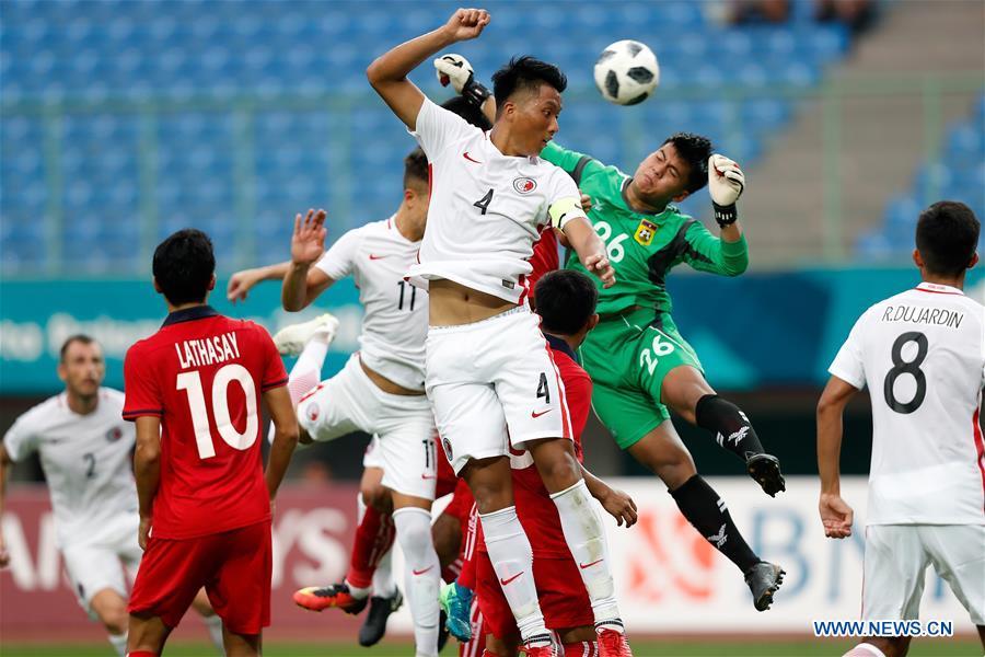 Lau Hok Ming (C) of Hong Kong of China vies with Paseuth Saymanolynh (2nd R) of Laos during the Men\'s Football Group A match at the 18th Asian Games at Patriot Stadium in Bekasi, Indonesia, Aug. 10, 2018. Hong Kong of China won 3-1. (Xinhua/Wang Lili)