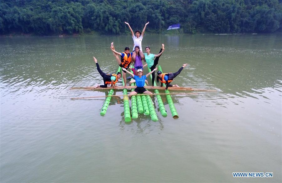 Middle school students practice single bamboo drifting on water in Rongjiang County, southwest China\'s Guizhou Province, Aug. 11, 2018. Single bamboo drifting originated in China\'s Guizhou and requires a person to stand or sit on a single piece of bamboo while performing graceful movements. (Xinhua/Wang Bingzhen)