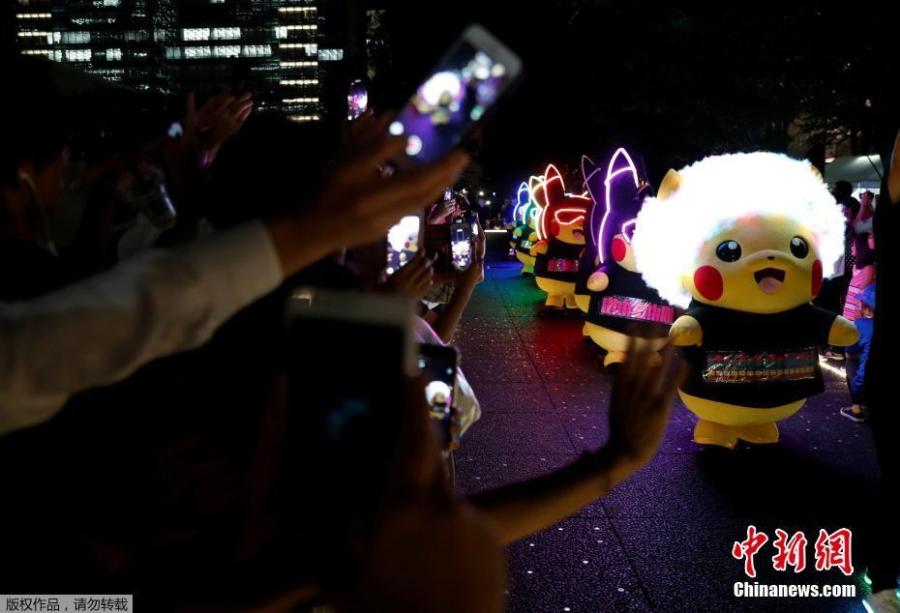 People take picture of performer swearing Pokemon\'s character Pikachu costumes during a night parade in Yokohama, Japan August 10, 2018. A total of over 1,500 Pikachus (in both frolicking and decorative forms) will be greeting visitors to Yokohama’s Minato Mirai harbor district. (Photo/Agencies)
