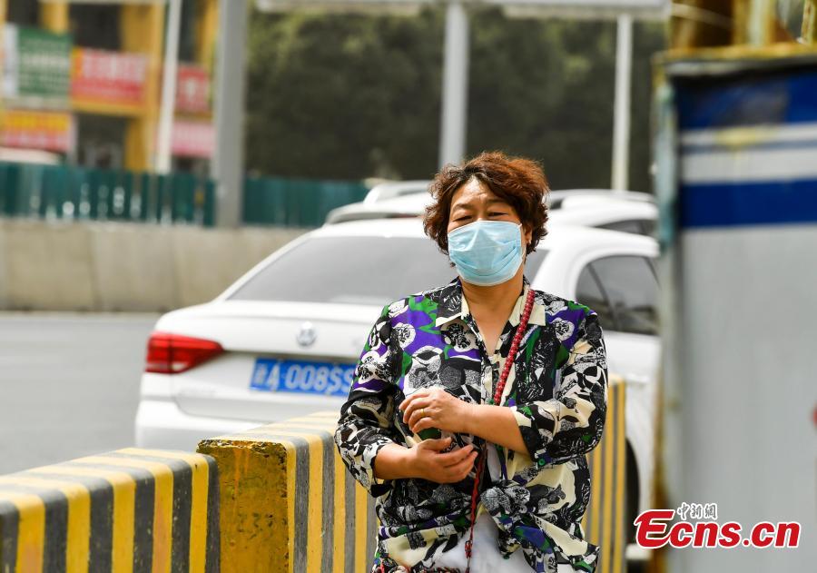 A woman wears a mask to protect her from a sandstorm while walking on a street in Urumqi, capital of Northwest China’s Xinjiang Uygur Autonomous Region, Aug. 12, 2018. Visibility was reduced as dust shrouded the city, where temperatures reached approximately 35 degrees centigrade. (Photo: China News Service/Liu Xin)