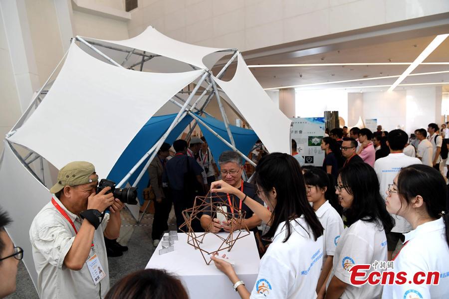 Students make an architectural model during a contest in Fuzhou City, East China\'s Fujian Province, Aug. 12, 2018. As part of the 6th Cross-Straits Youth Festival, 140 students from 15 universities in the Chinese mainland and Taiwan participated in the architectural model design contest. (Photo: China News Service/Zhang Bin)