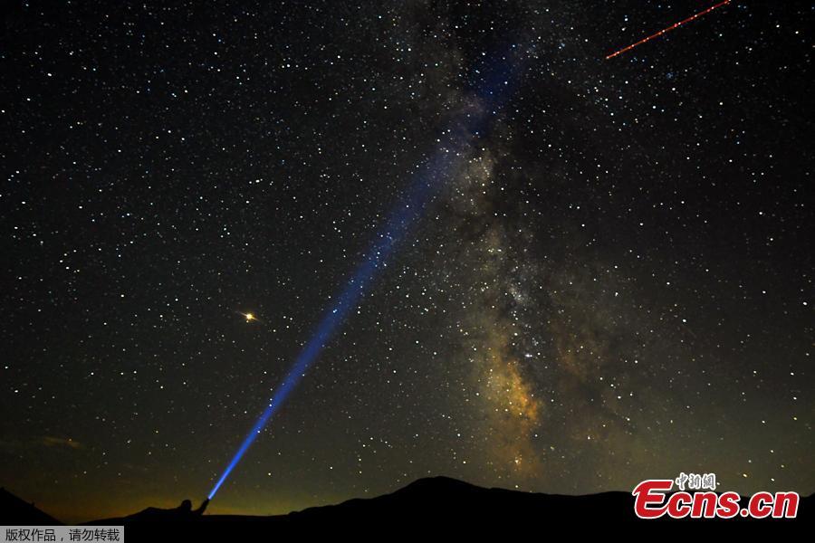 A man points his light at the Milky Way during the peak of the Perseid meteor shower at Mavrovo national park in Macedonia August 12, 2018. (Photo/Agencies)