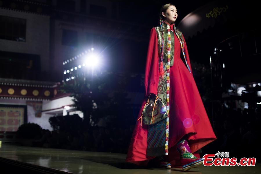 A model presents an outfit during a fashion show in Lhasa, Tibet Autonomous Region, Aug. 12, 2018. Models presented 84 designs including 26 traditional Tibetan costumes in the fashion show organized by Tibet Vocational Technical College and the Beijing Institute of Fashion Technology. (Photo/Xinhua)