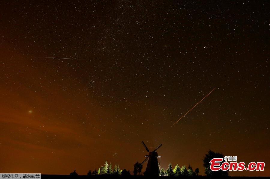 A meteor (L) and plane (R) tracks are seen in the night sky during the Perseid meteor shower near the village of Ptich, Belarus, August 13, 2018. (Photo/Agencies)