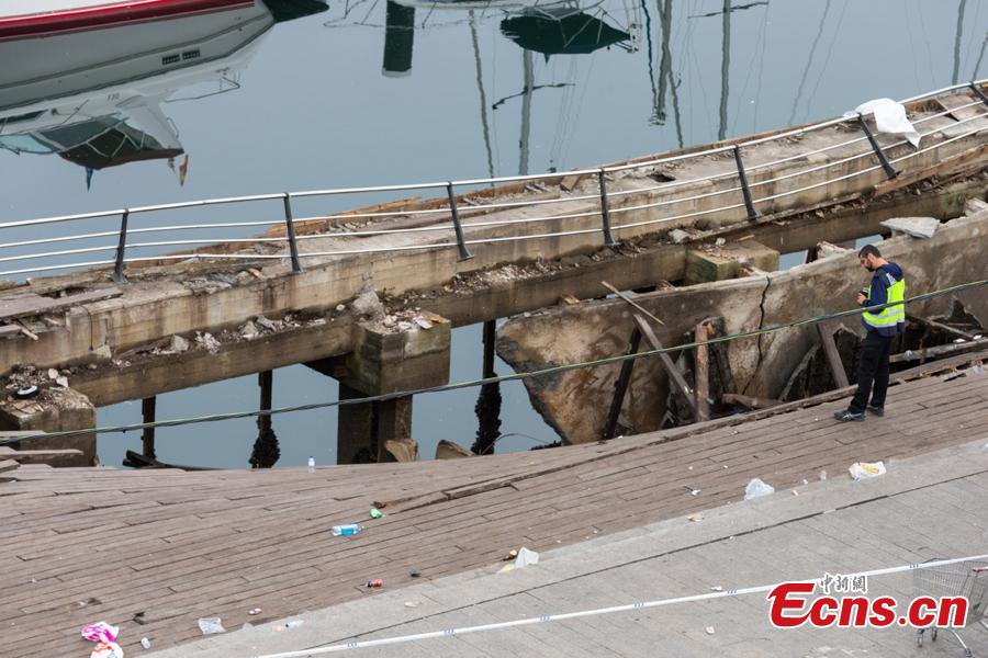 A police investigator inspects the seafront platform in Vigo on August 13, 2018 after a section of a wooden promenade suddenly collapsed with people watching a rap artist just before midnight on Sunday. More than 300 people were injured, including nine seriously, the regional government of Galicia said in a statement. (Photo/Agencies)