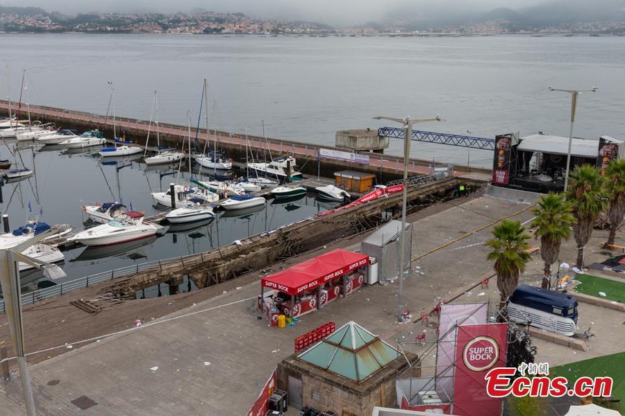 A police investigator inspects the seafront platform in Vigo on August 13, 2018 after a section of a wooden promenade suddenly collapsed with people watching a rap artist just before midnight on Sunday. More than 300 people were injured, including nine seriously, the regional government of Galicia said in a statement. (Photo/Agencies)