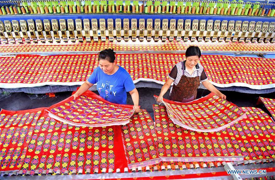 Two women work in a knitting workshop in Gezhuang Village of Shiqiao Town in Yiyuan County, east China\'s Shandong Province, Aug. 14, 2018. In recent years, Yiyuan government has made efforts on the development of knitting and embroidery industry. Through establishing cooperatives and industry associations, the government helps to open up domestic and international market for products and raise income for the locals. (Xinhua/Zhao Dongshan)