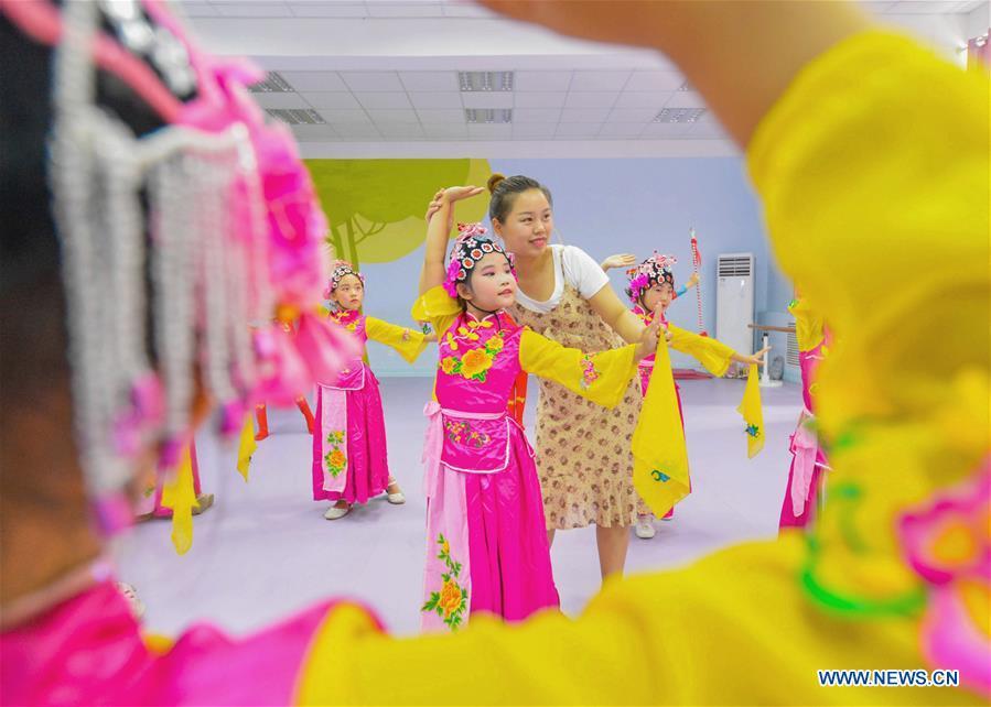Students learn basic skills of traditional Chinese opera at a primary school in Hanshan District of Handan, north China\'s Hebei Province, Aug. 14, 2018. The school organized traditional Chinese arts activities for students to enrich their summer vacation life. (Xinhua/Wang Xiao)